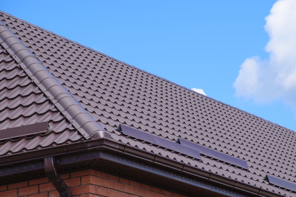 A Brown Roof With a Blue Sky in the Background — Bradshaw Plumbing & Roofing Pty Ltd In Ooralea, QLD A Brown Roof With a Blue Sky in the Background — Bradshaw Plumbing & Roofing Pty Ltd In Ooralea, QLD