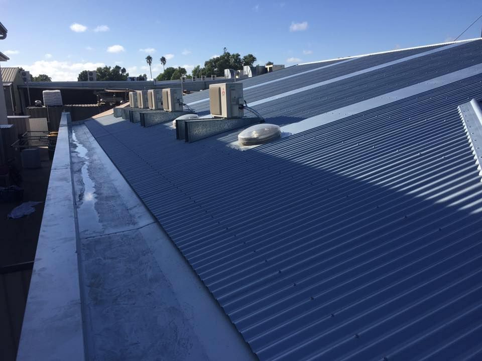 A Blue Roof With a Drain on the Side of It — Bradshaw Plumbing & Roofing Pty Ltd In East Mackay, QLD A Blue Roof With a Drain on the Side of It — Bradshaw Plumbing & Roofing Pty Ltd In East Mackay, QLD