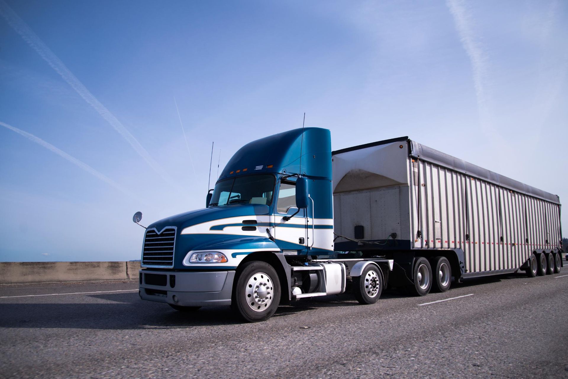 A blue semi truck is parked on the side of the road.