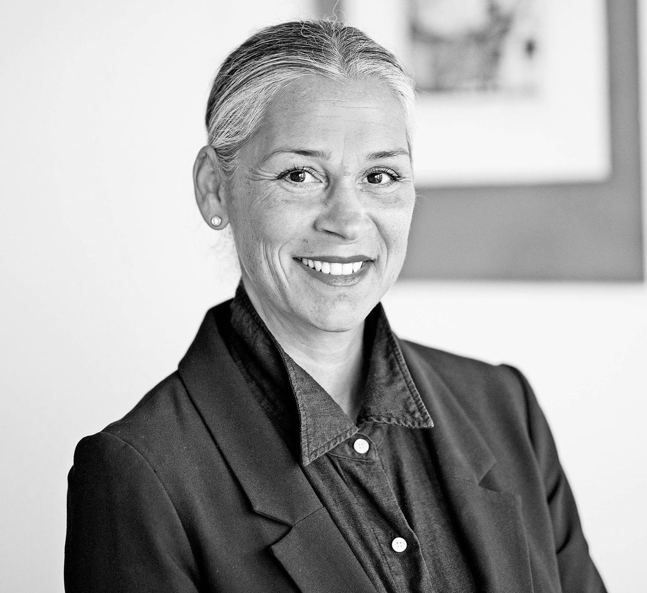 Auf einem Schwarzweißfoto lächelt eine Frau in einem schwarzen Pulli.