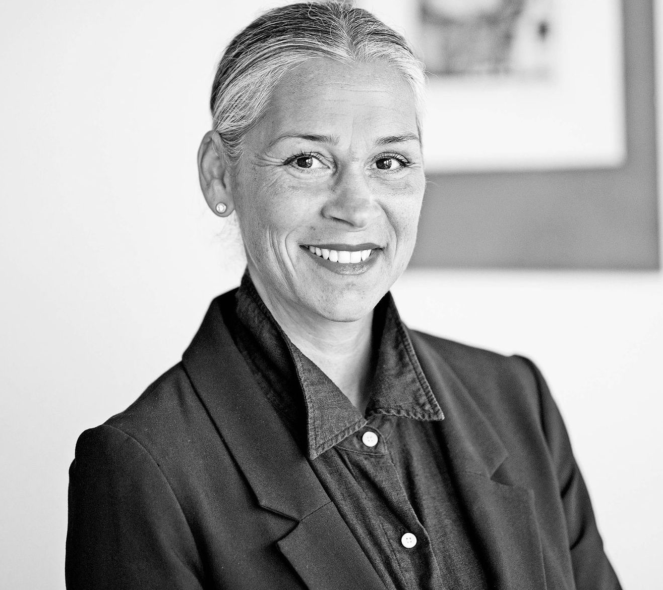 Auf einem Schwarzweißfoto lächelt eine Frau in einem schwarzen Pulli.