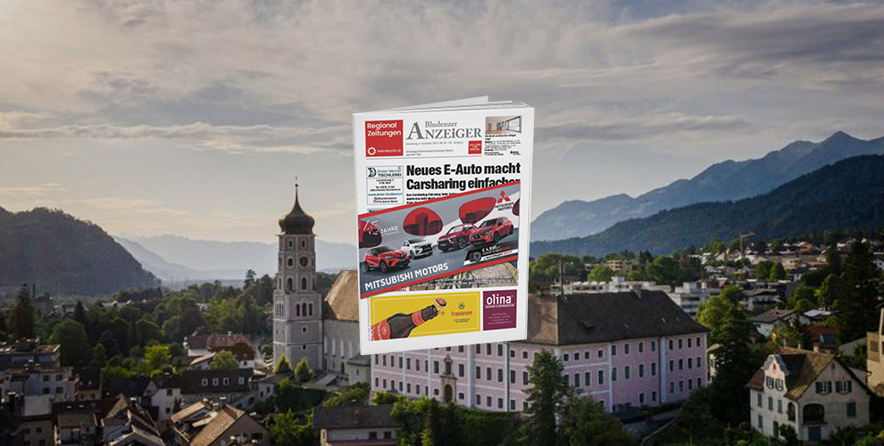 Eine Zeitung liegt auf einem Gebäude vor einem Berg.