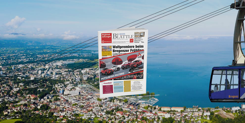 Eine Zeitung hängt in einer Seilbahn über einer Stadt.