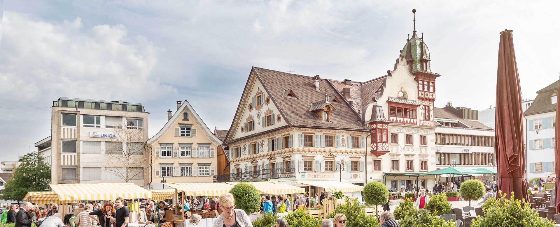 Eine Menschenmenge hat sich vor einem großen Gebäude mit einem Uhrenturm versammelt.