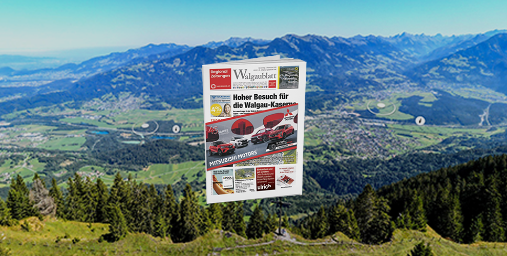 Eine Zeitschrift liegt auf einem Berggipfel vor einer Bergkette.