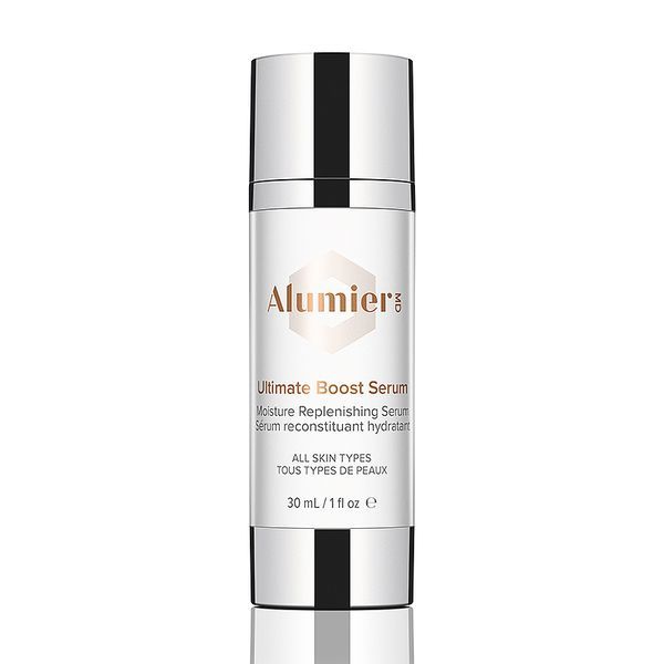 A bottle of ultimate boost serum is sitting on a white surface.