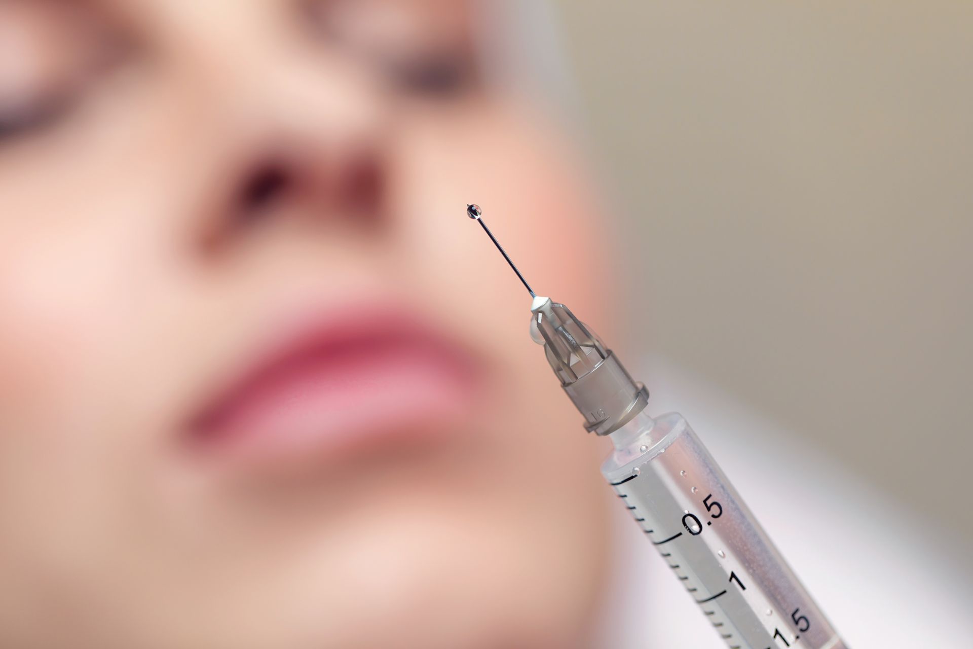 a close up of a syringe in front of a woman 's face