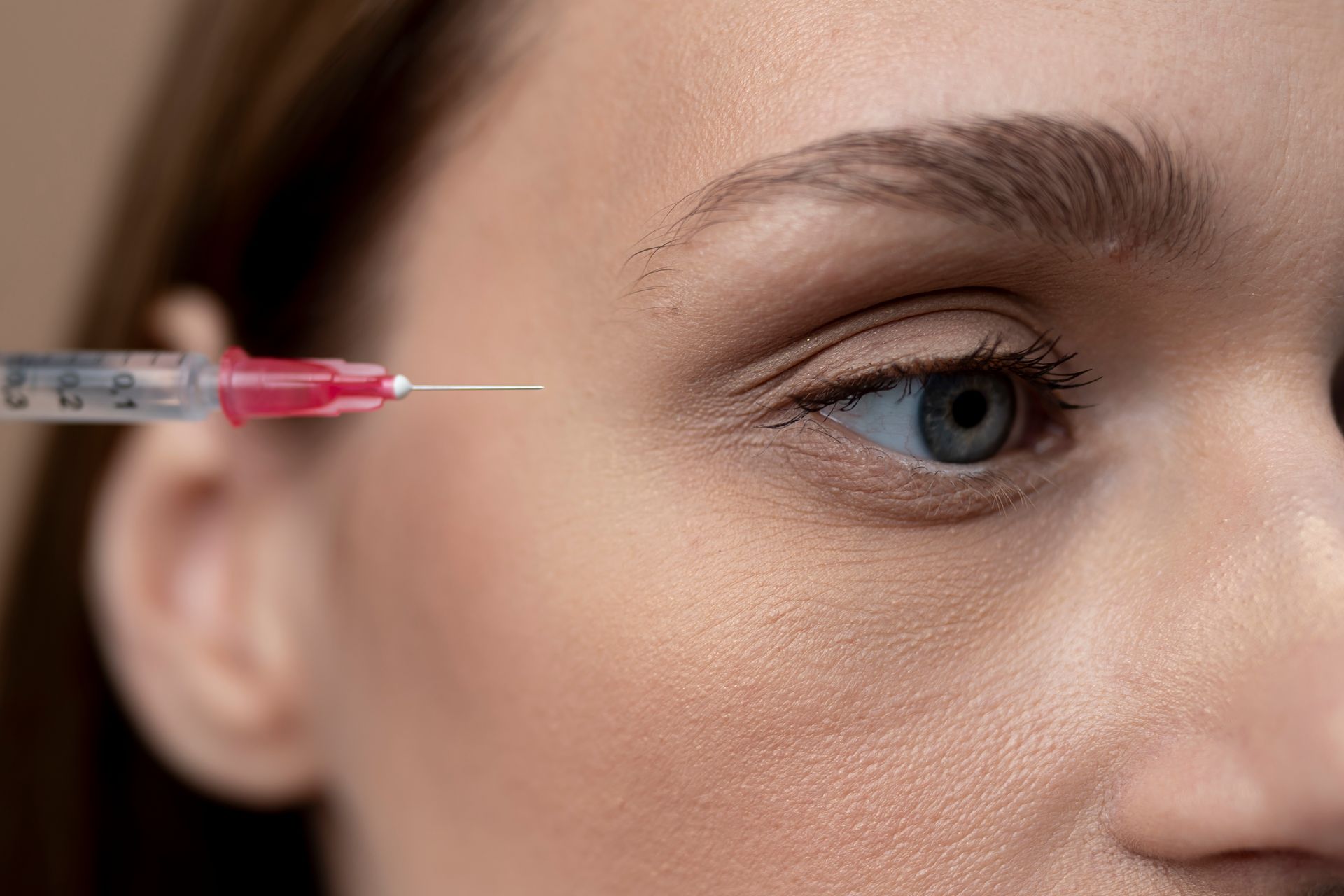 A woman is getting a botox injection in her eye.