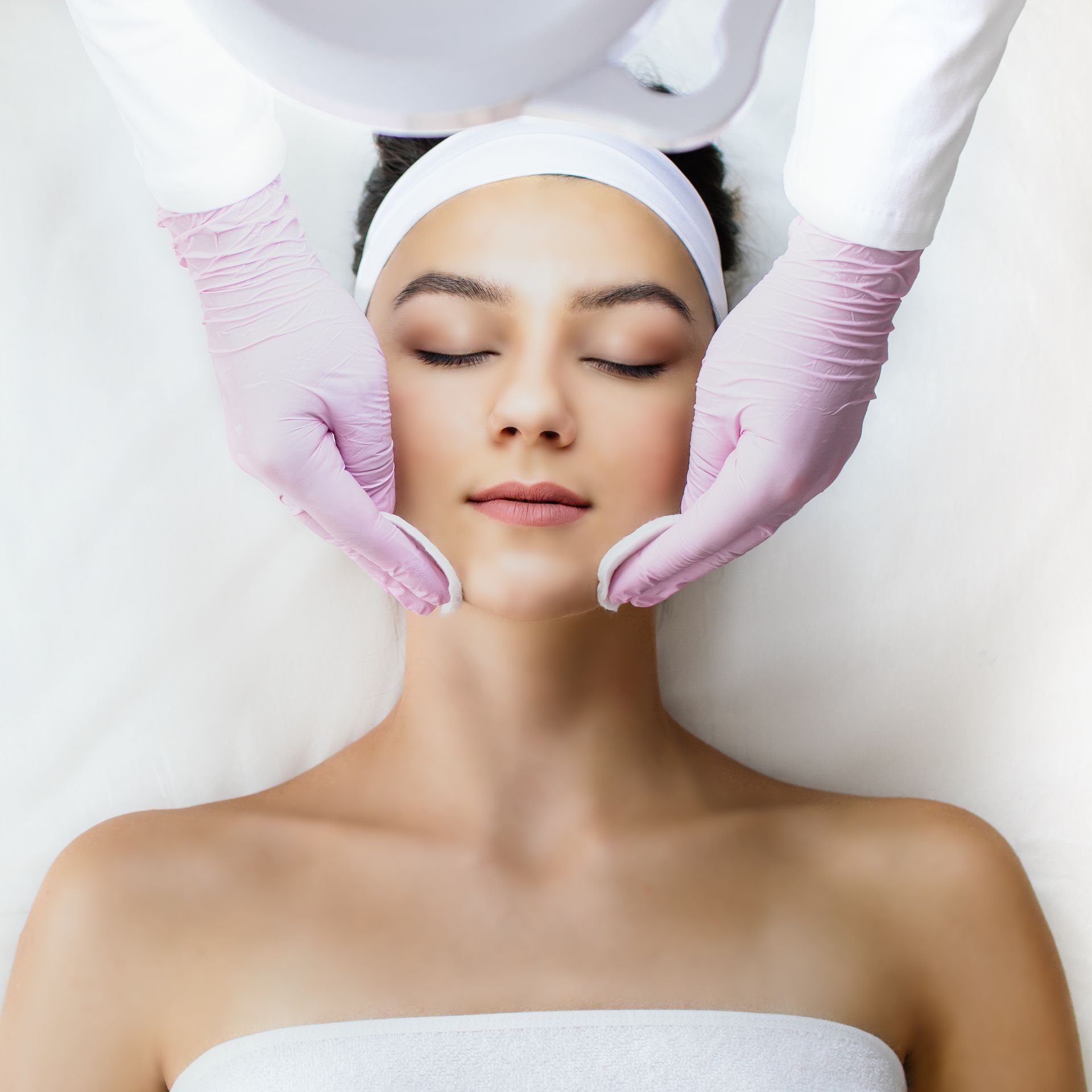 A woman is getting a facial treatment at a beauty salon.