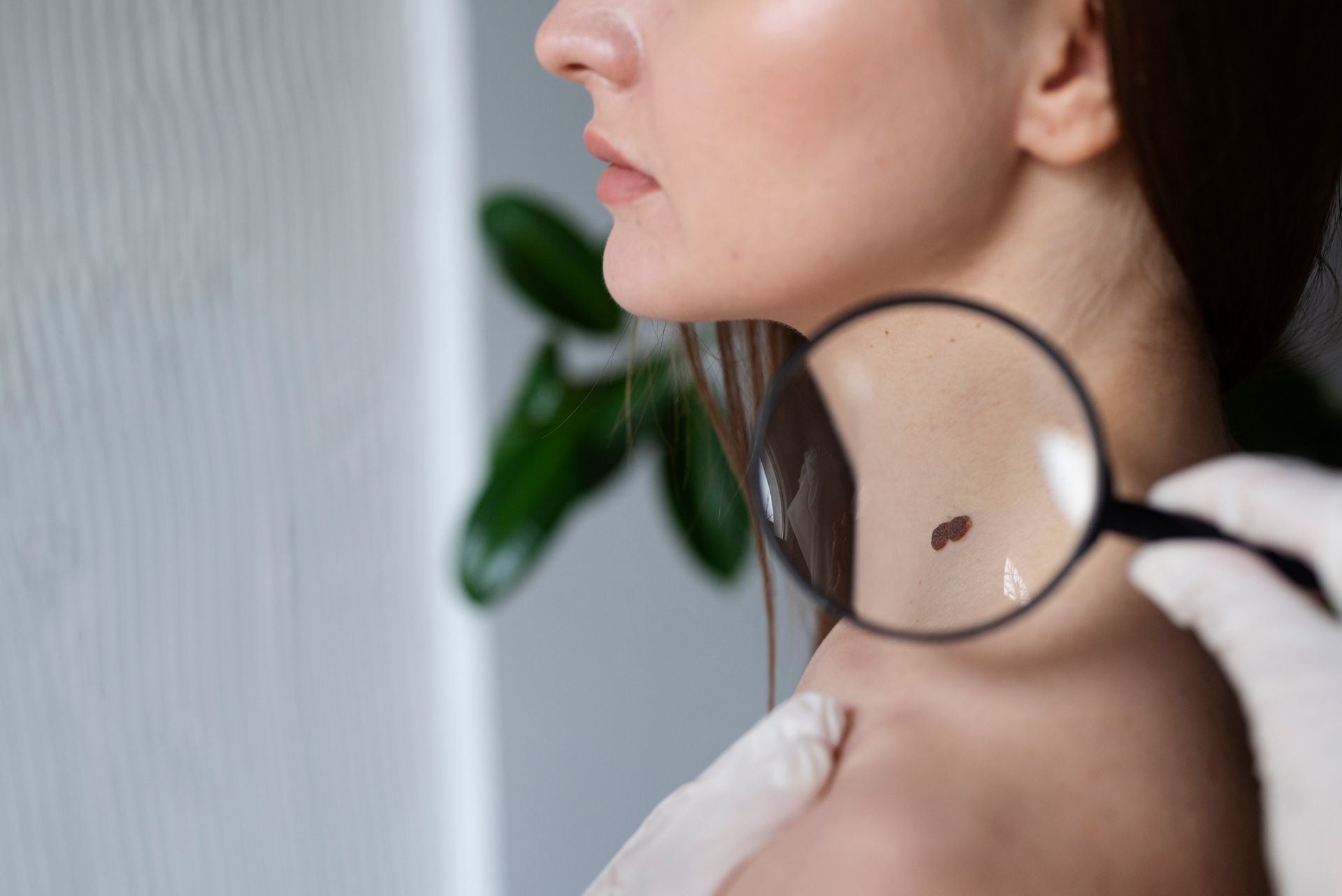 A doctor is examining a woman 's neck with a magnifying glass.