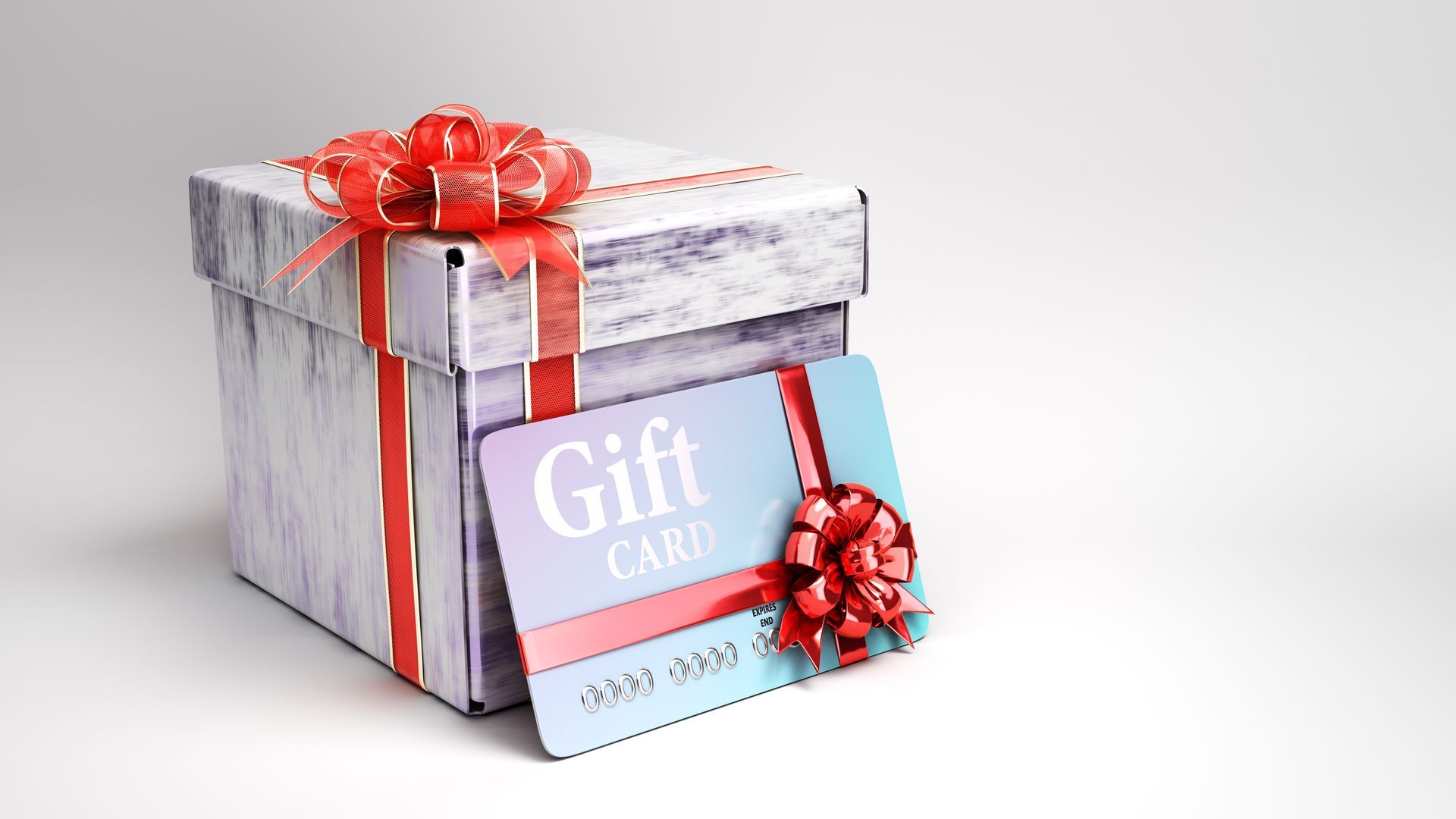 Gift box with red ribbon and gift card, light blue with red bow, against a white background.