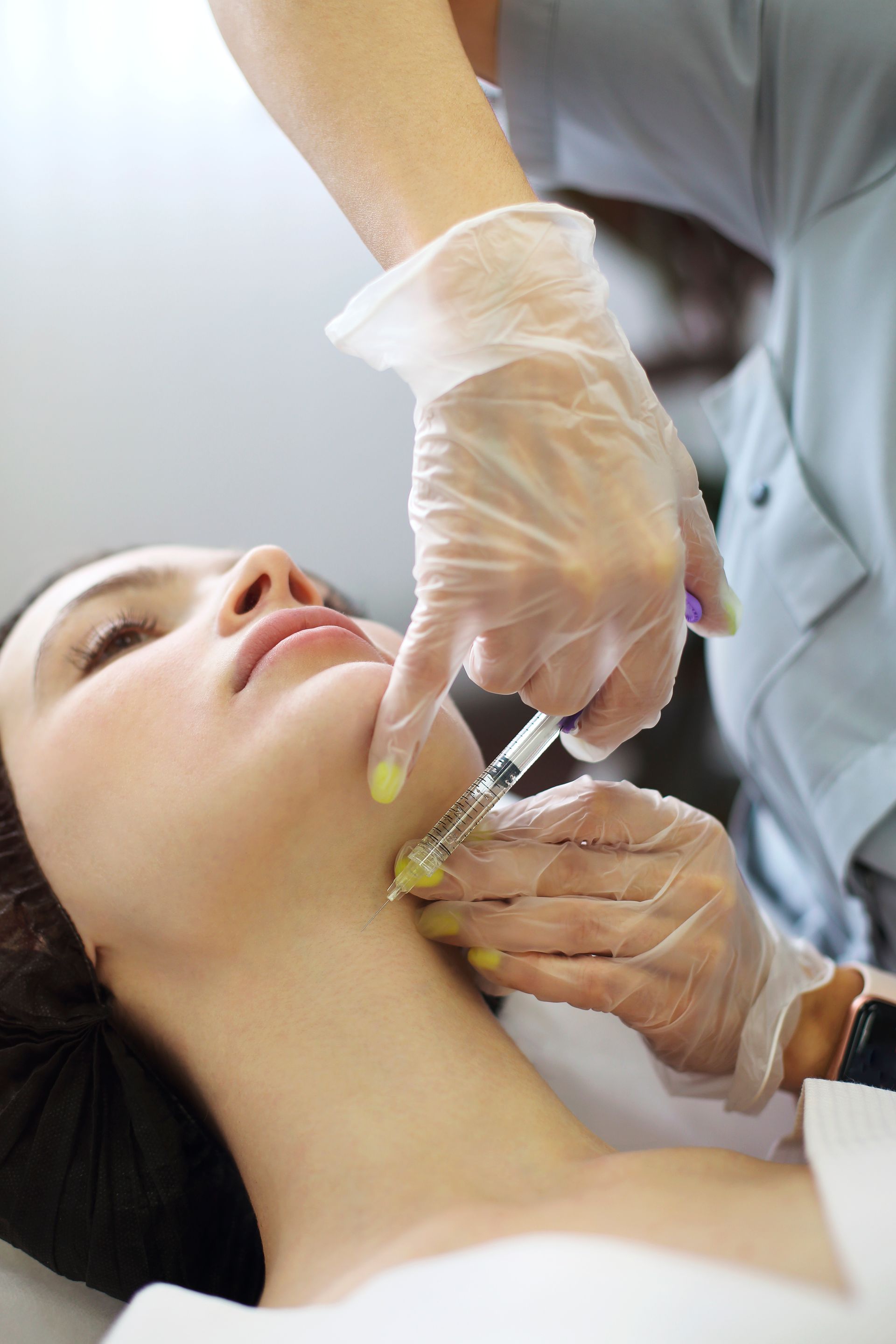 a woman is getting a botox injection in her neck .