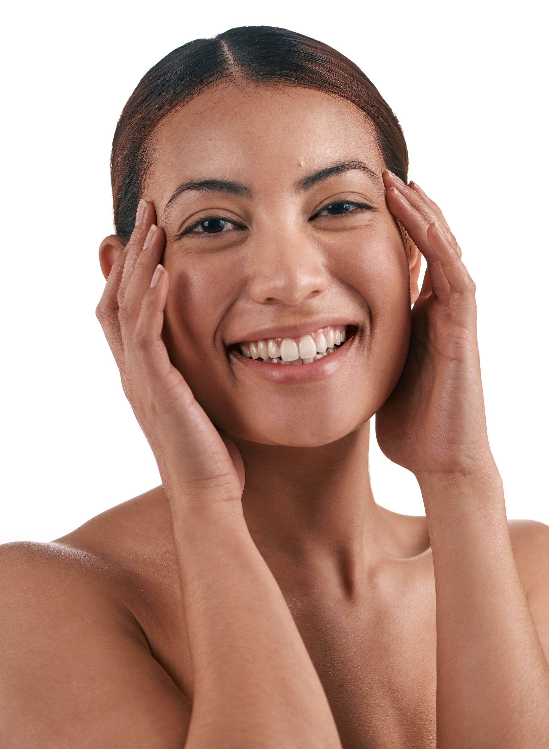 a woman is smiling and touching her face with her hands .