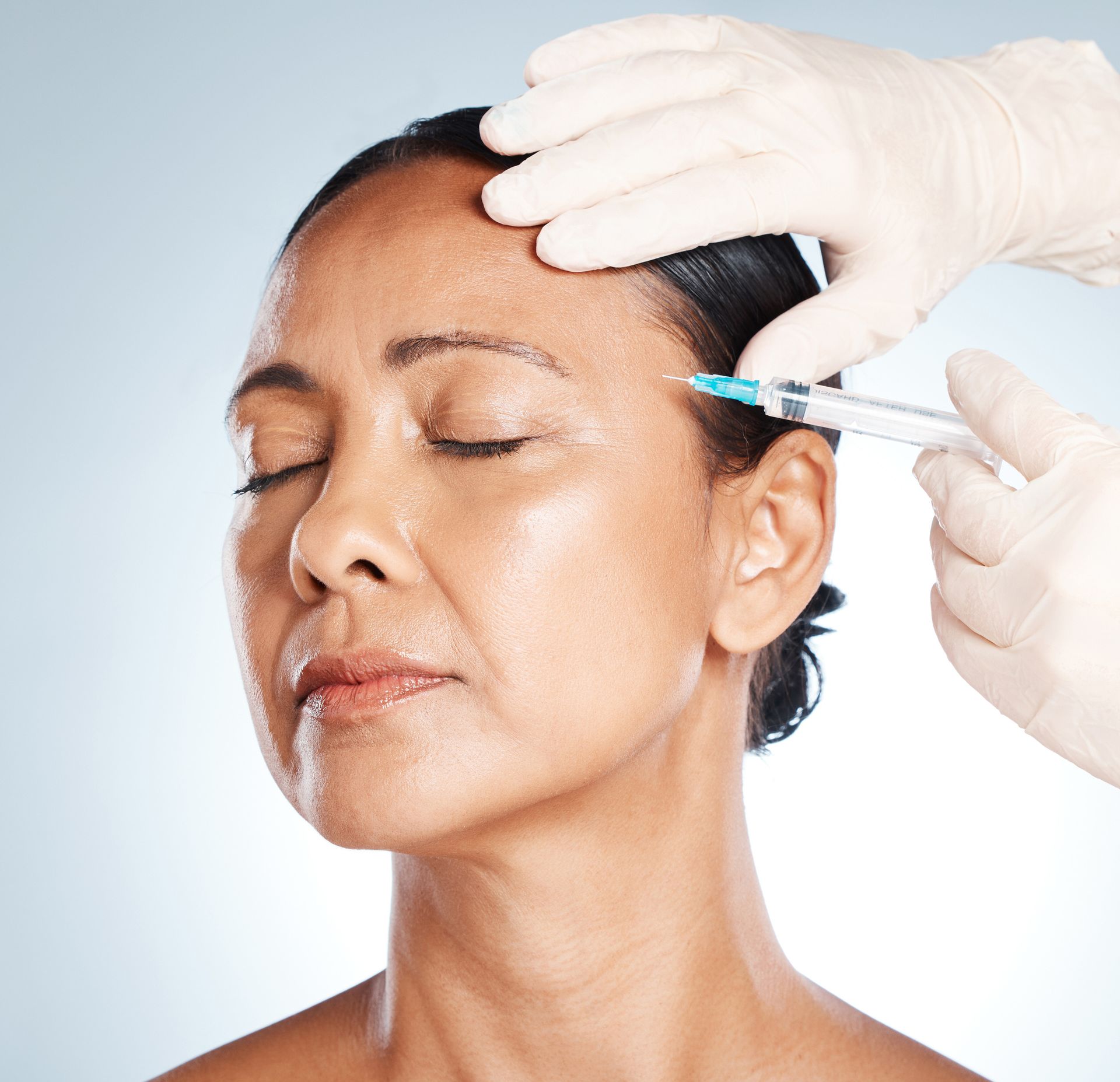 a woman is getting a botox injection in her forehead