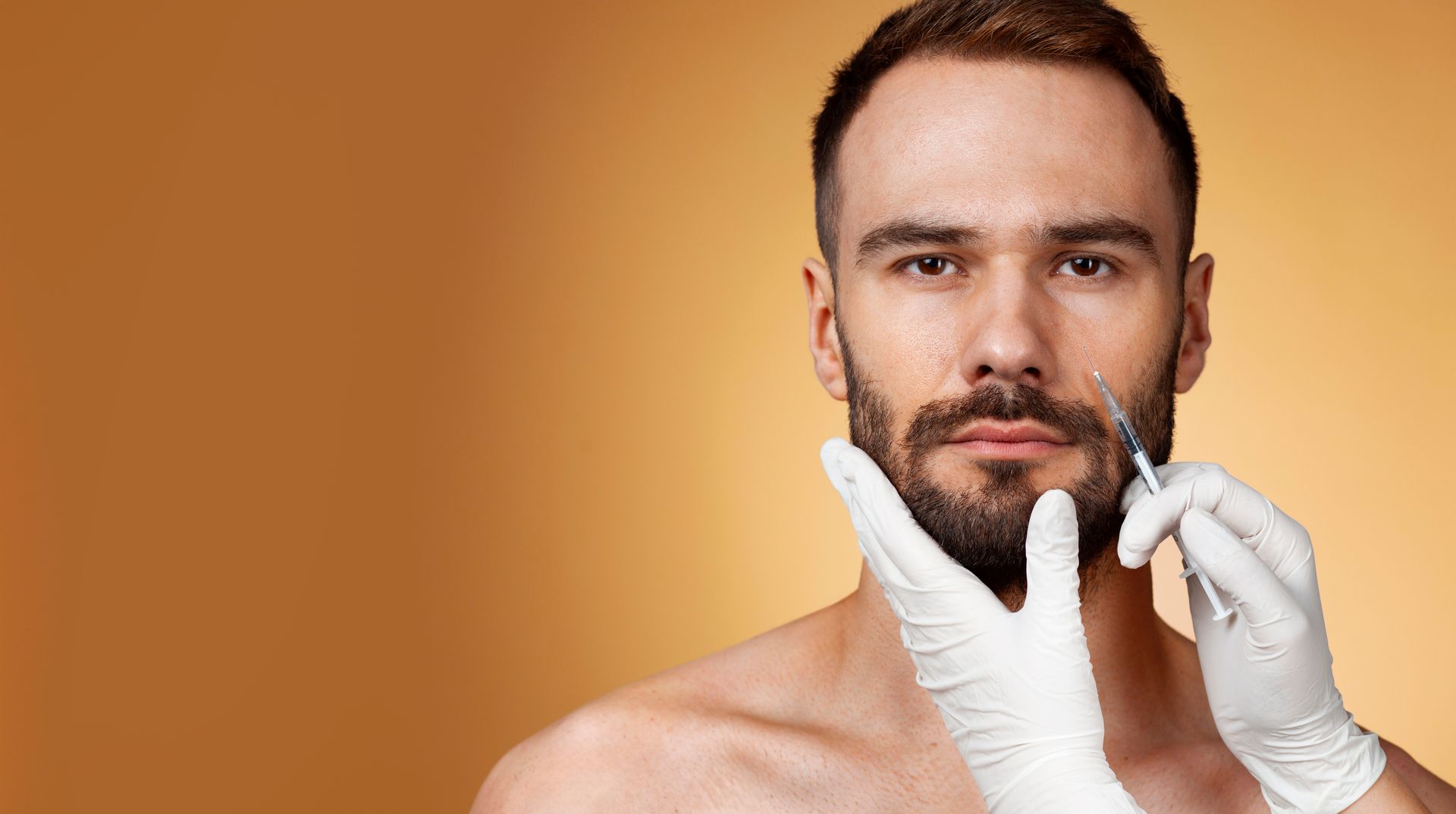 Man receiving facial injections; medical professional holding syringe near mouth, hands gloved.