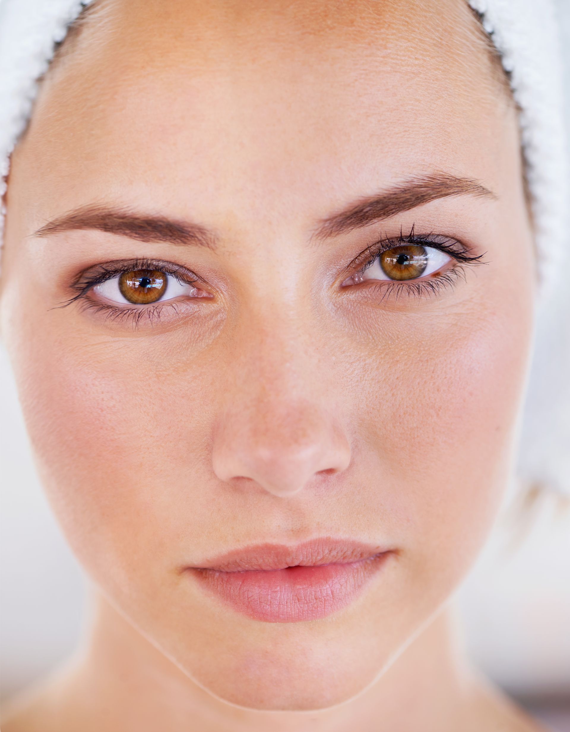 A close up of a woman 's face with a towel on her head.