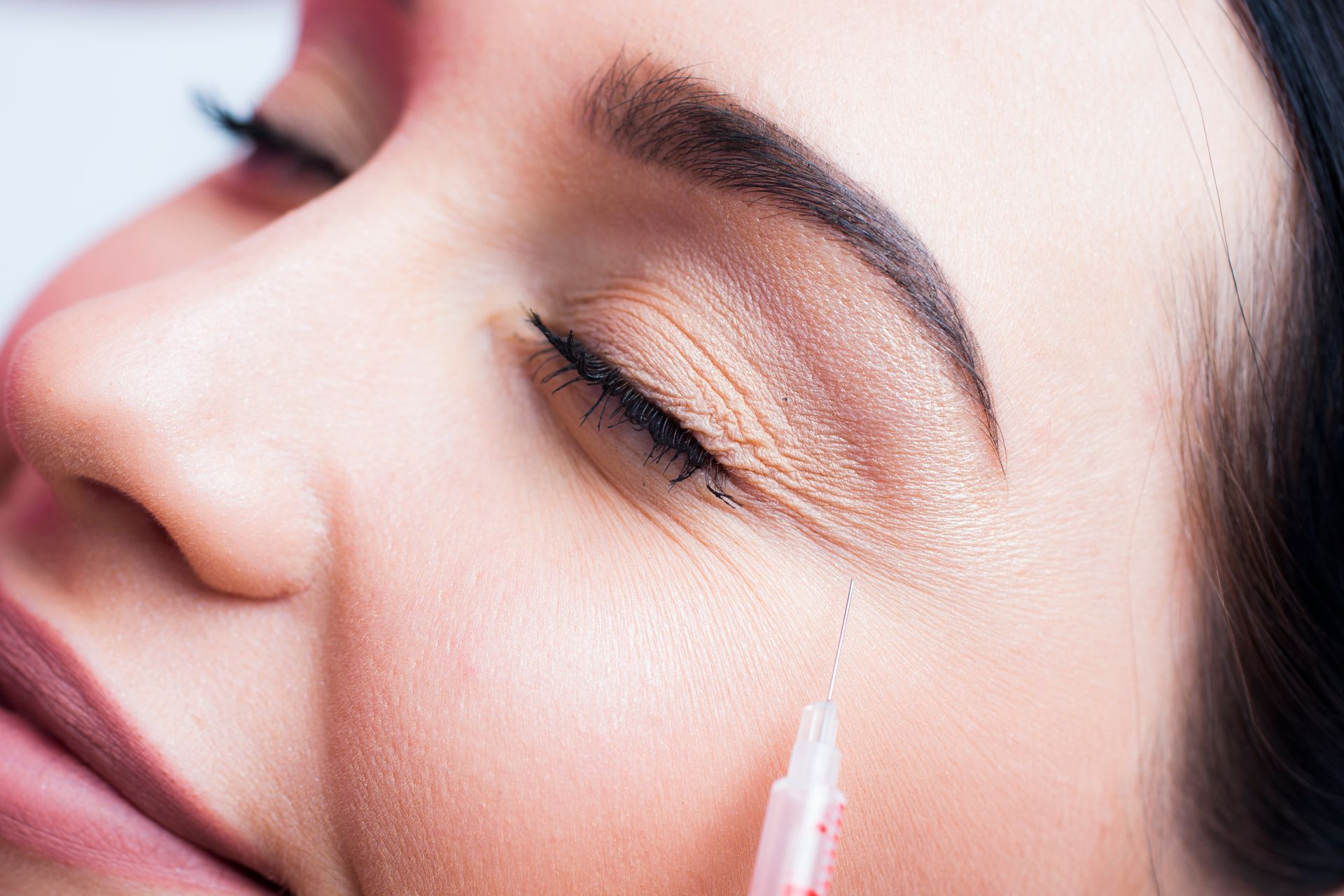 a woman is getting a botox injection in her face .