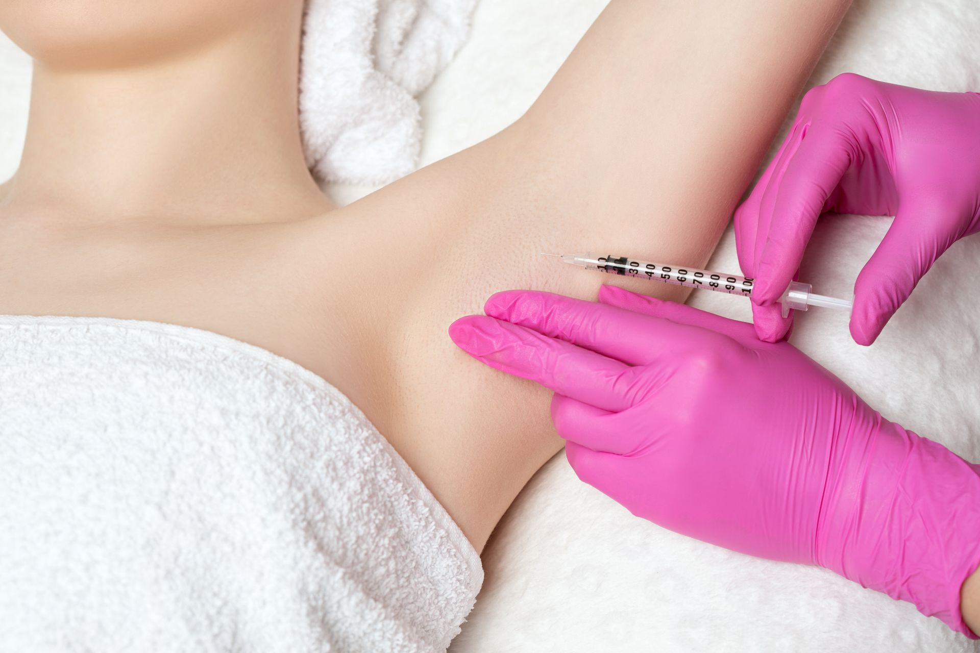 a woman is getting an underarm injection in a beauty salon .