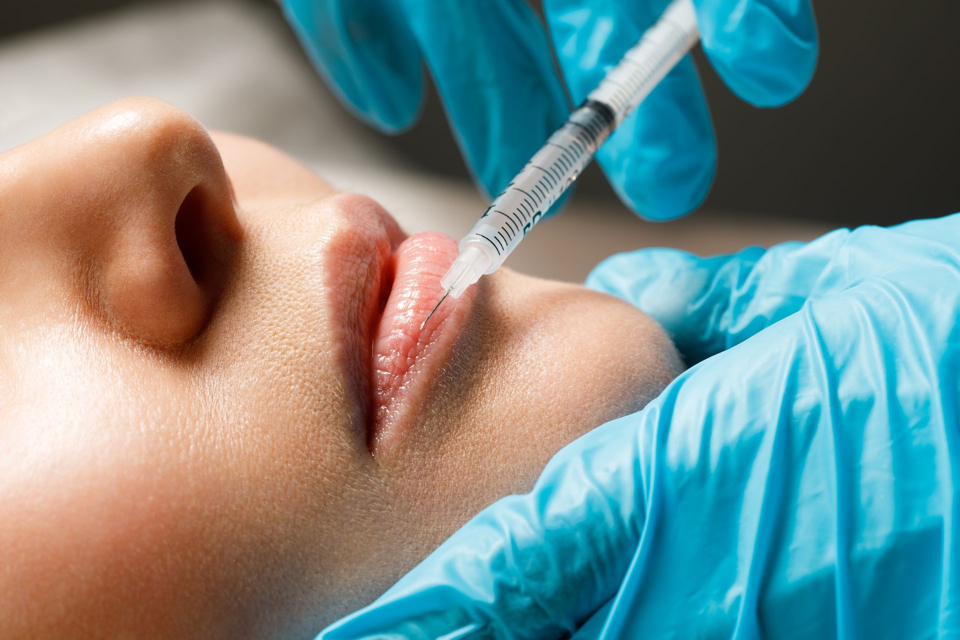 a woman is getting a botox injection in her lips .