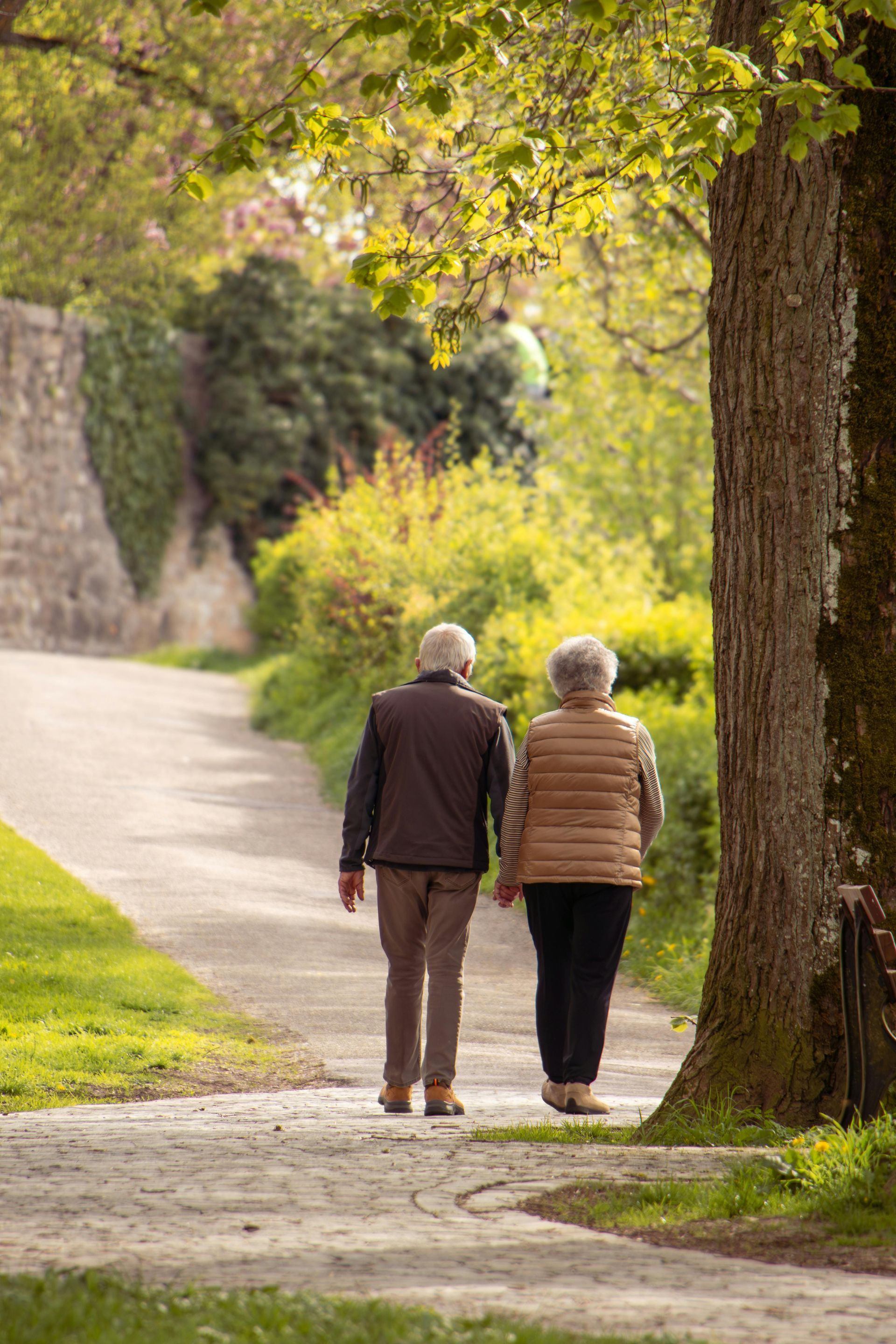 A man with a backpack is standing next to a lake in the woods.