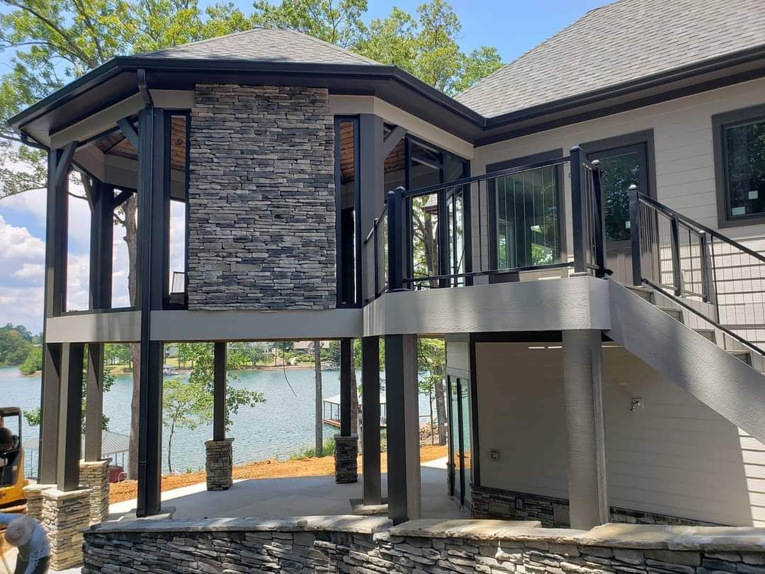 a large house with a deck and stairs overlooking a lake