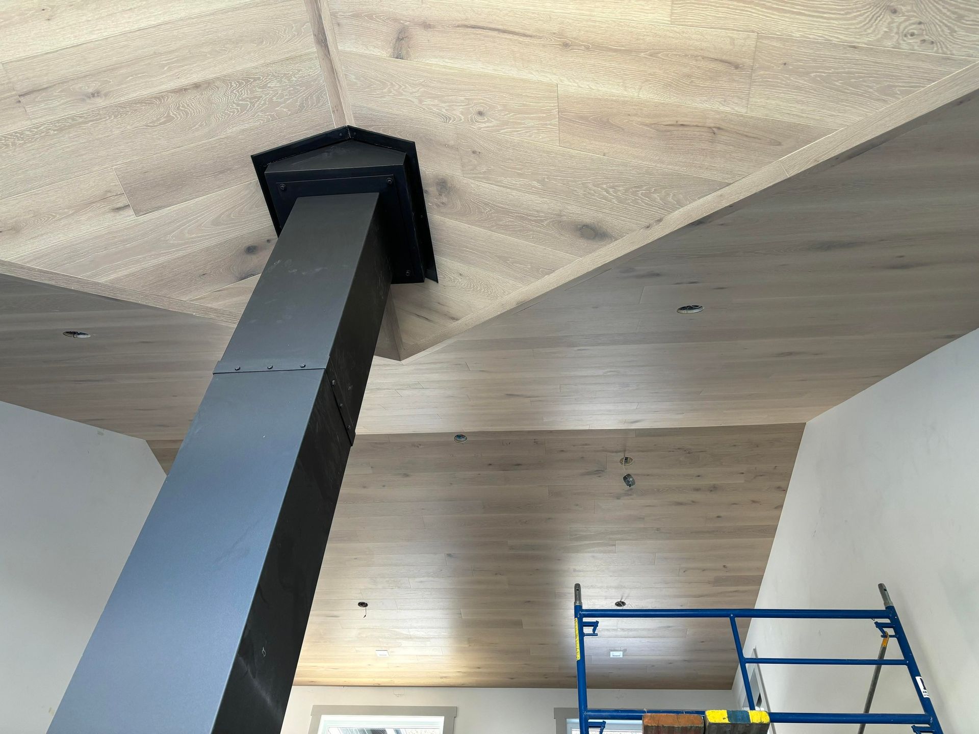 Une pièce avec un plafond en bois et une cheminée.