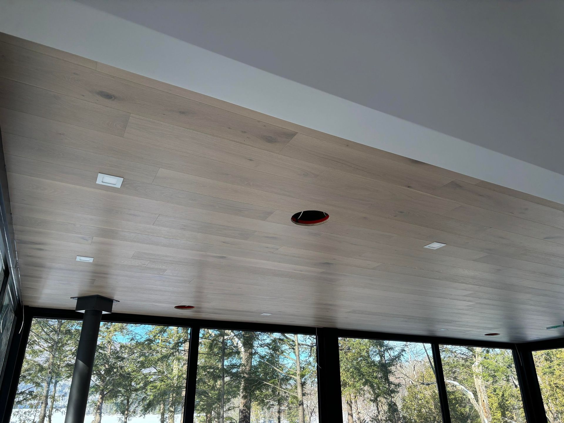 Une pièce avec un plafond en bois et beaucoup de fenêtres.