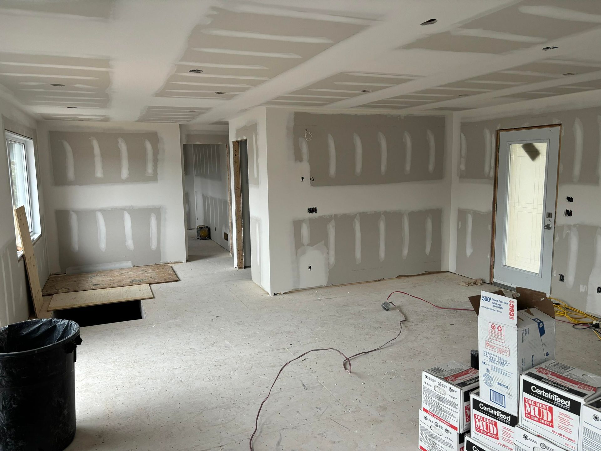 Une pièce en cours de rénovation avec des cartons empilés sur le sol