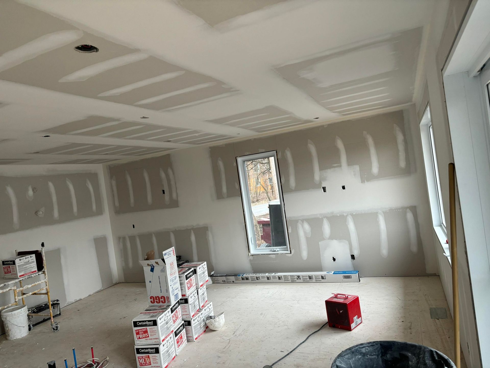 Une pièce en cours de rénovation avec des cartons par terre.