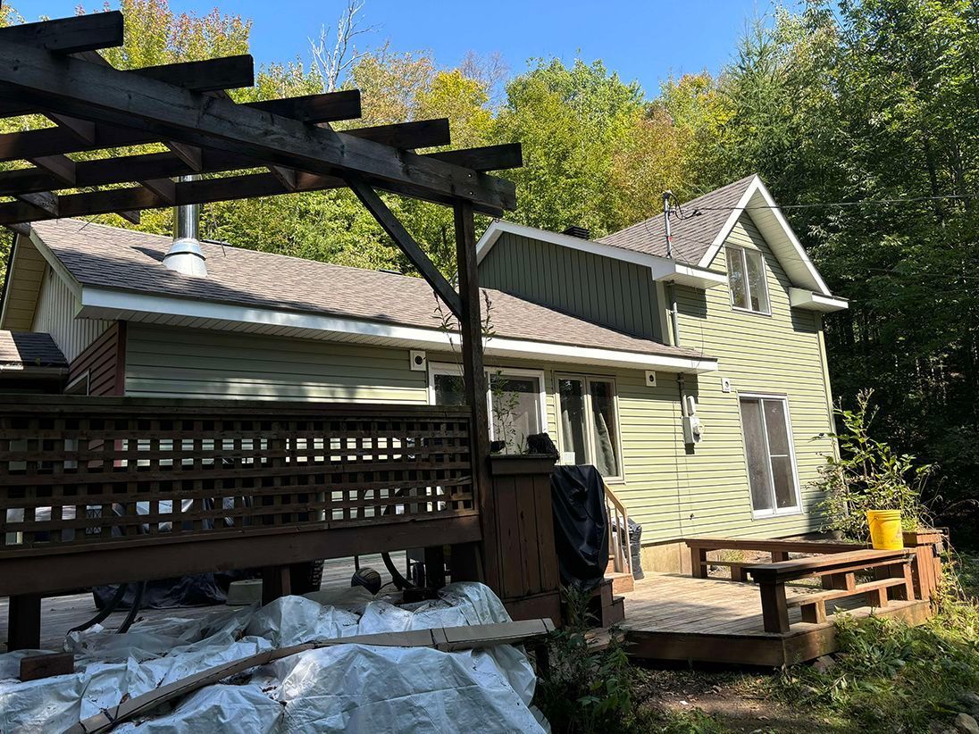 Une maison avec une terrasse et une pergola devant.