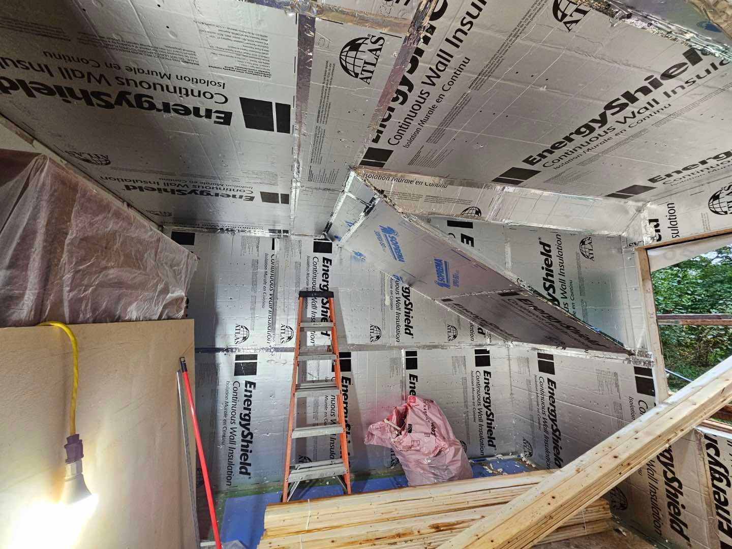 Une pièce avec une échelle et beaucoup d'isolation au plafond.