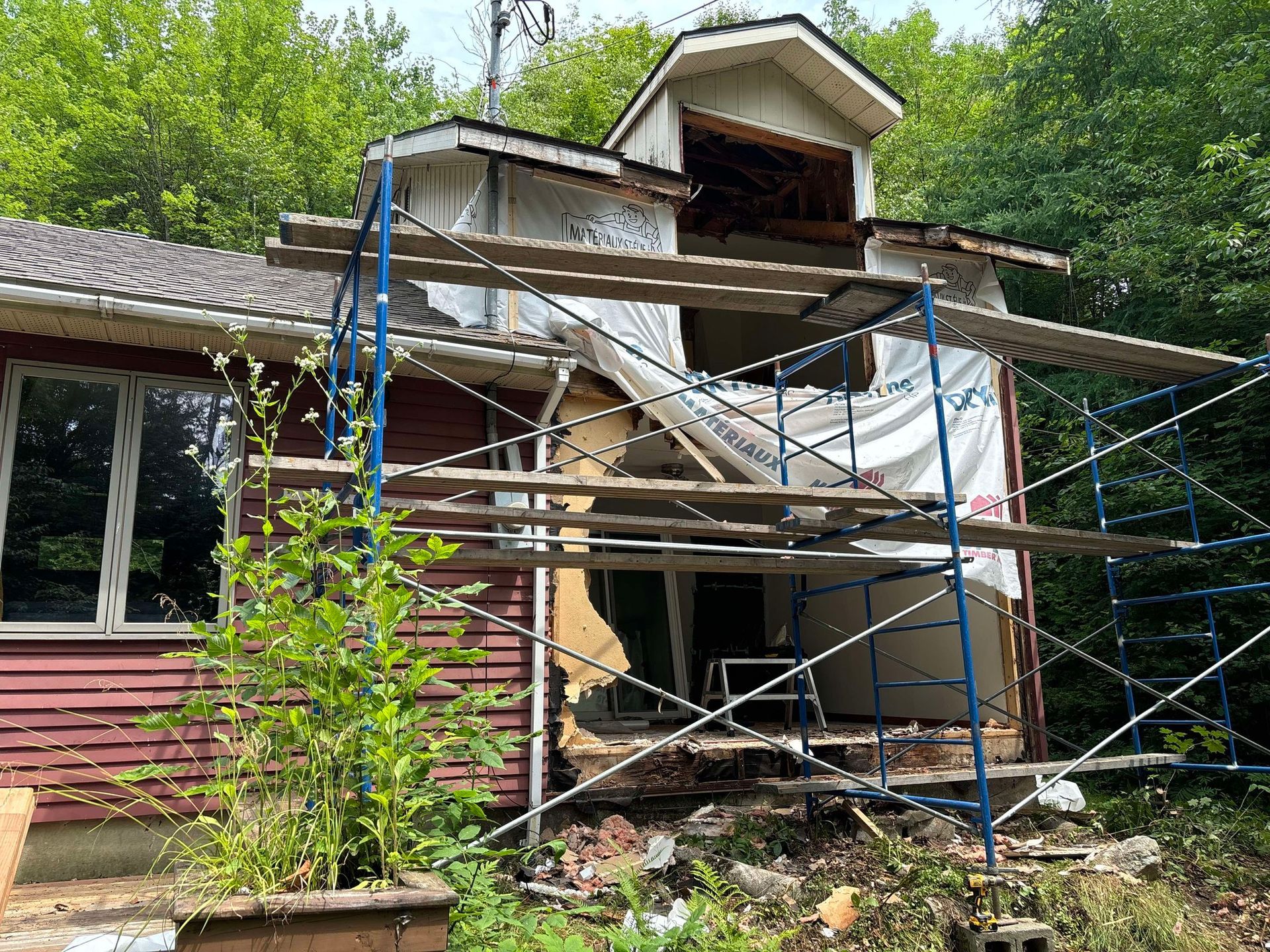Une maison est en cours de rénovation avec des échafaudages autour.