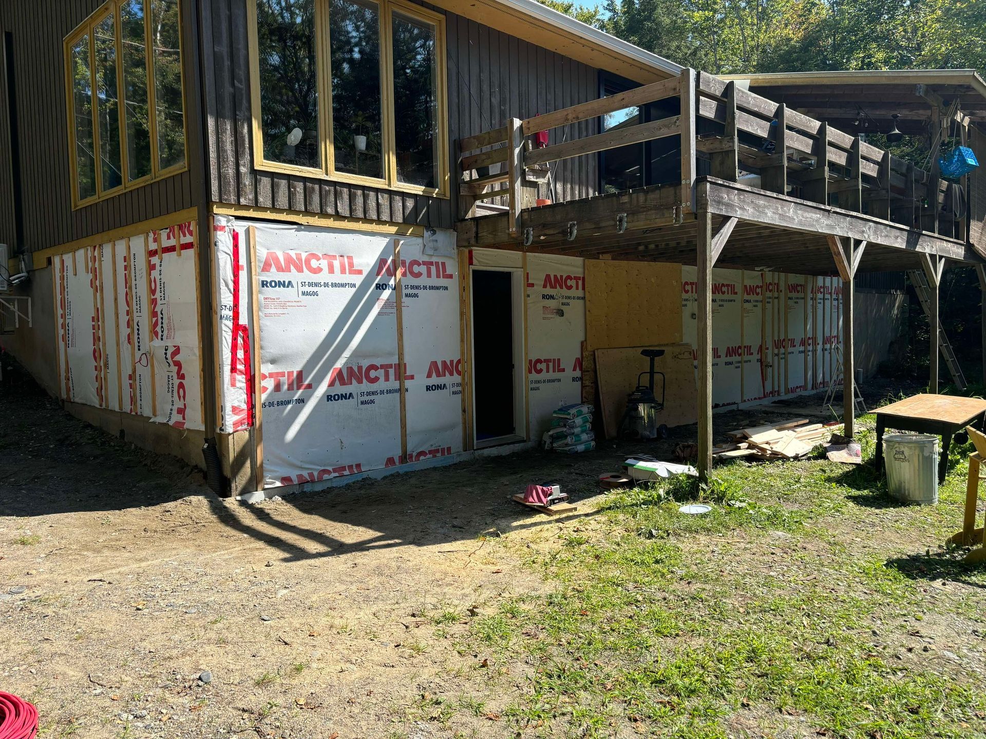 Une maison avec une terrasse et beaucoup de fenêtres est en construction.
