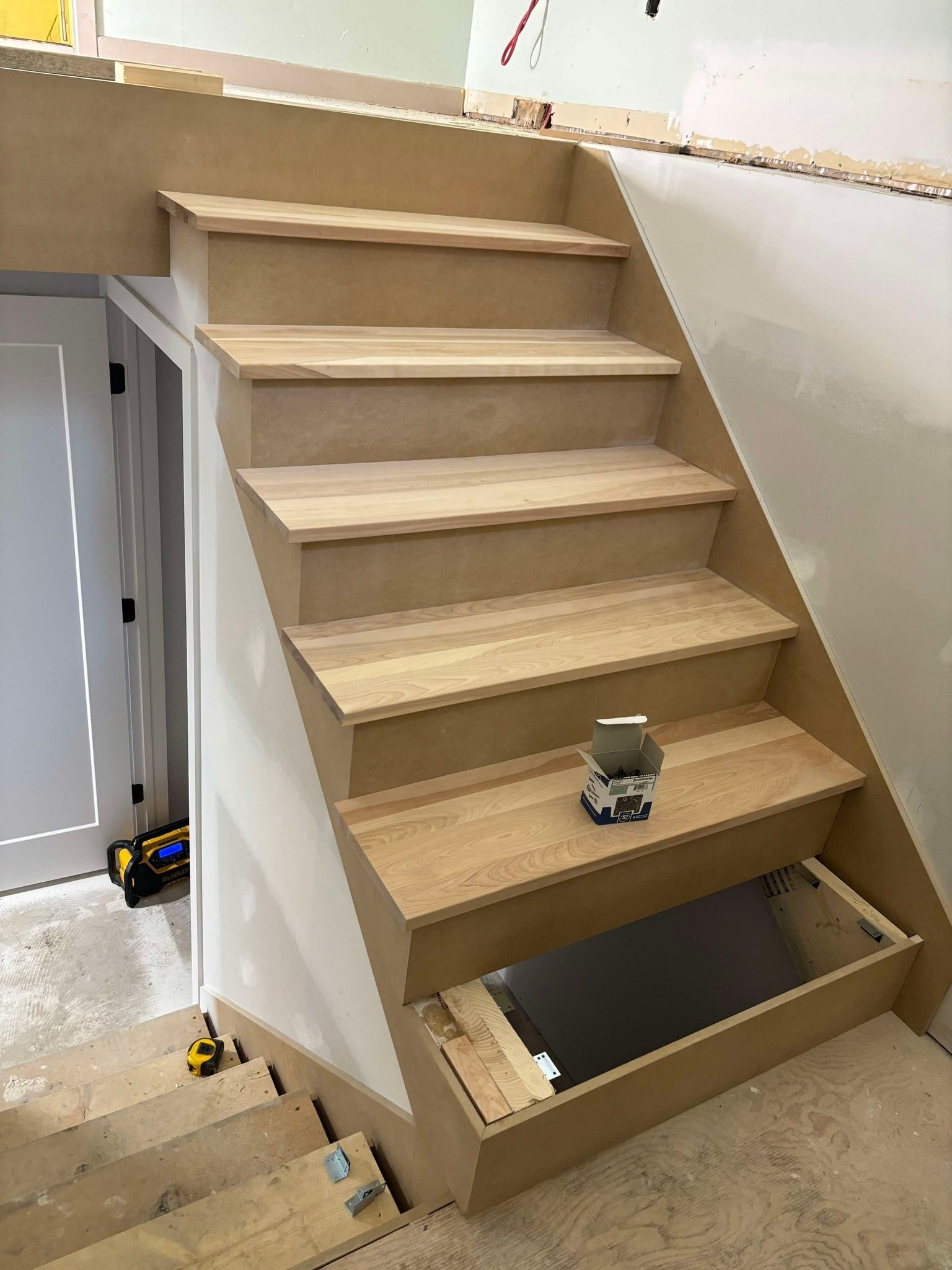 Un escalier en bois est en cours de construction dans une pièce.