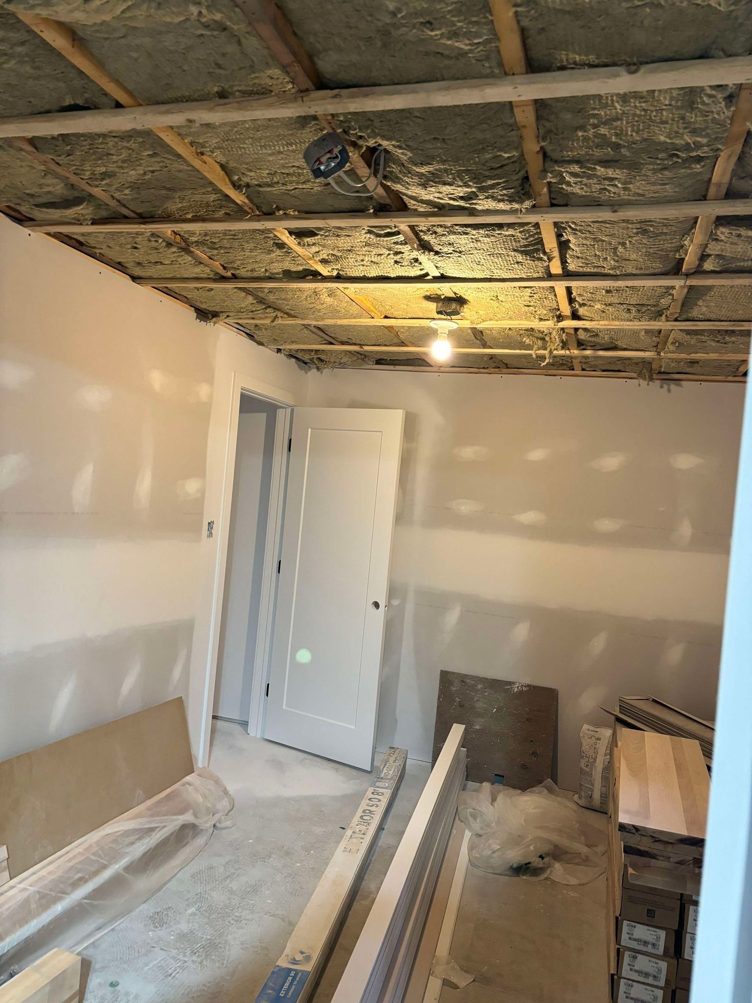 Une pièce avec une porte et une lumière au plafond.