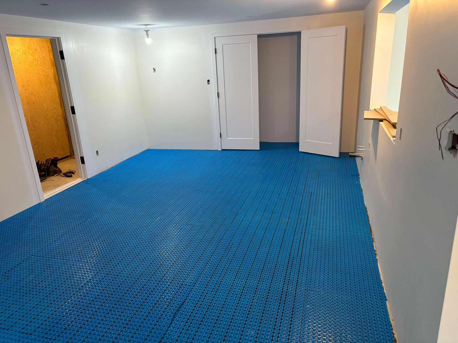Une pièce avec un sol bleu et des murs blancs.