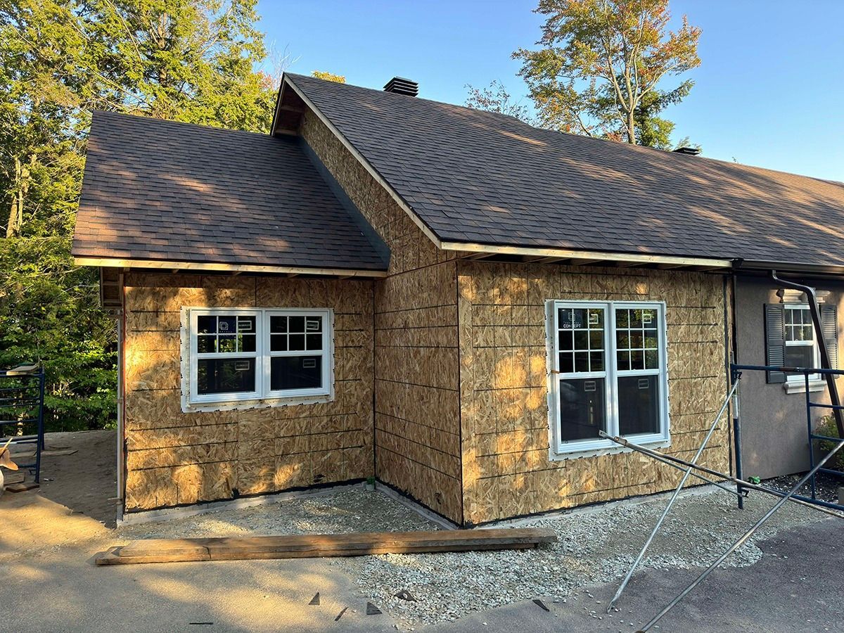 Une maison est en construction avec un toit et des fenêtres.