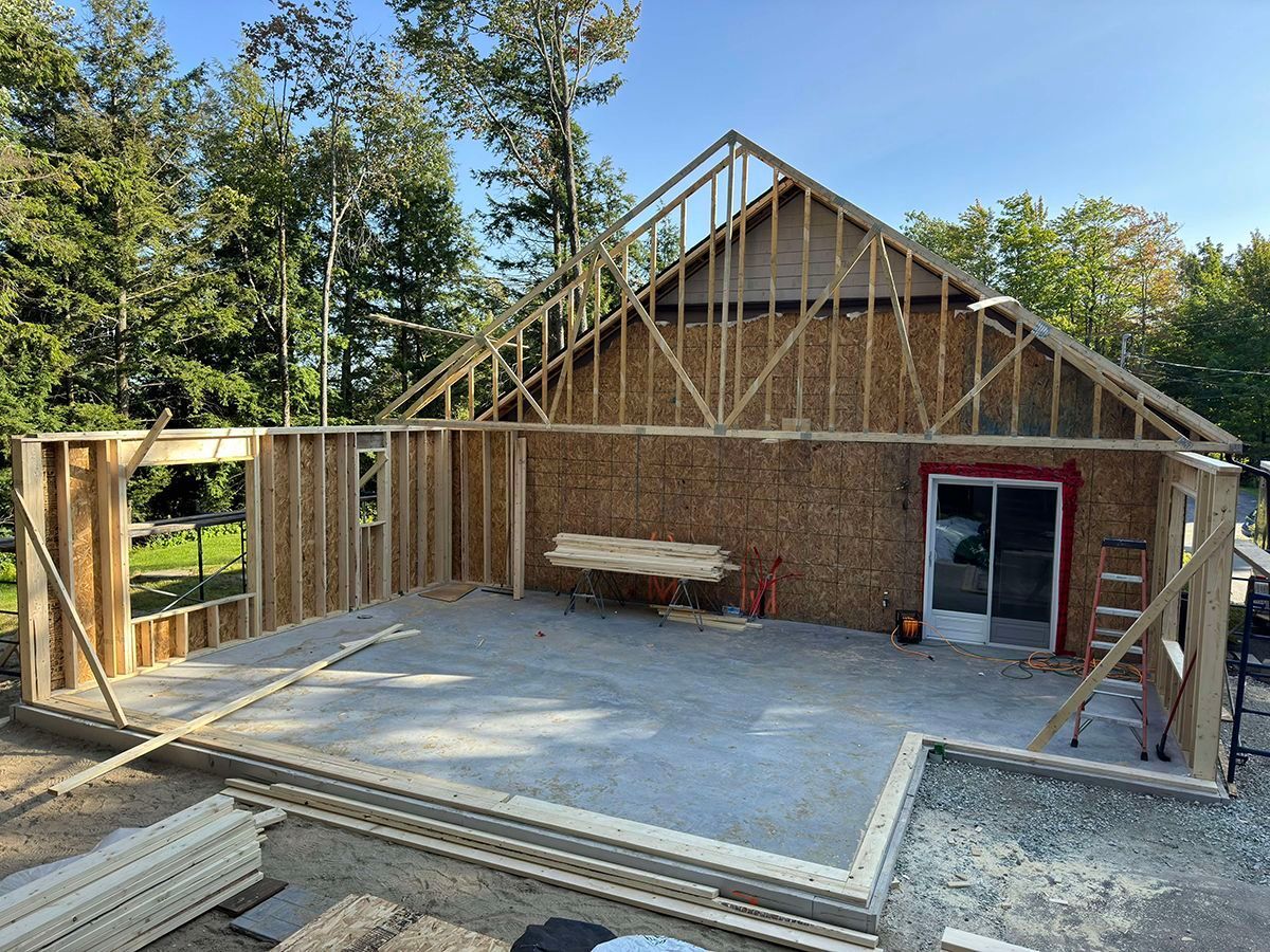 Une maison est en train d'être construite avec des poutres en bois et un toit.
