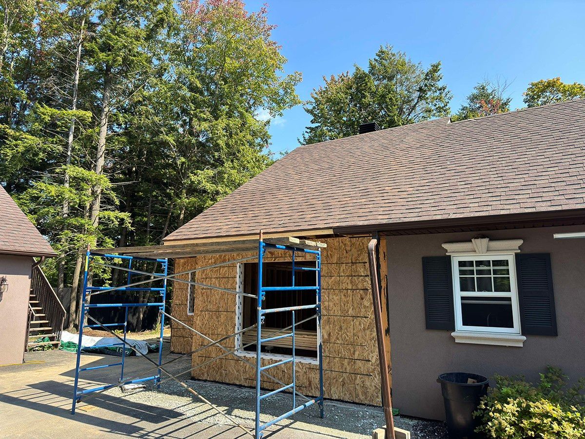 Une maison est en cours de rénovation avec un échafaudage devant elle.