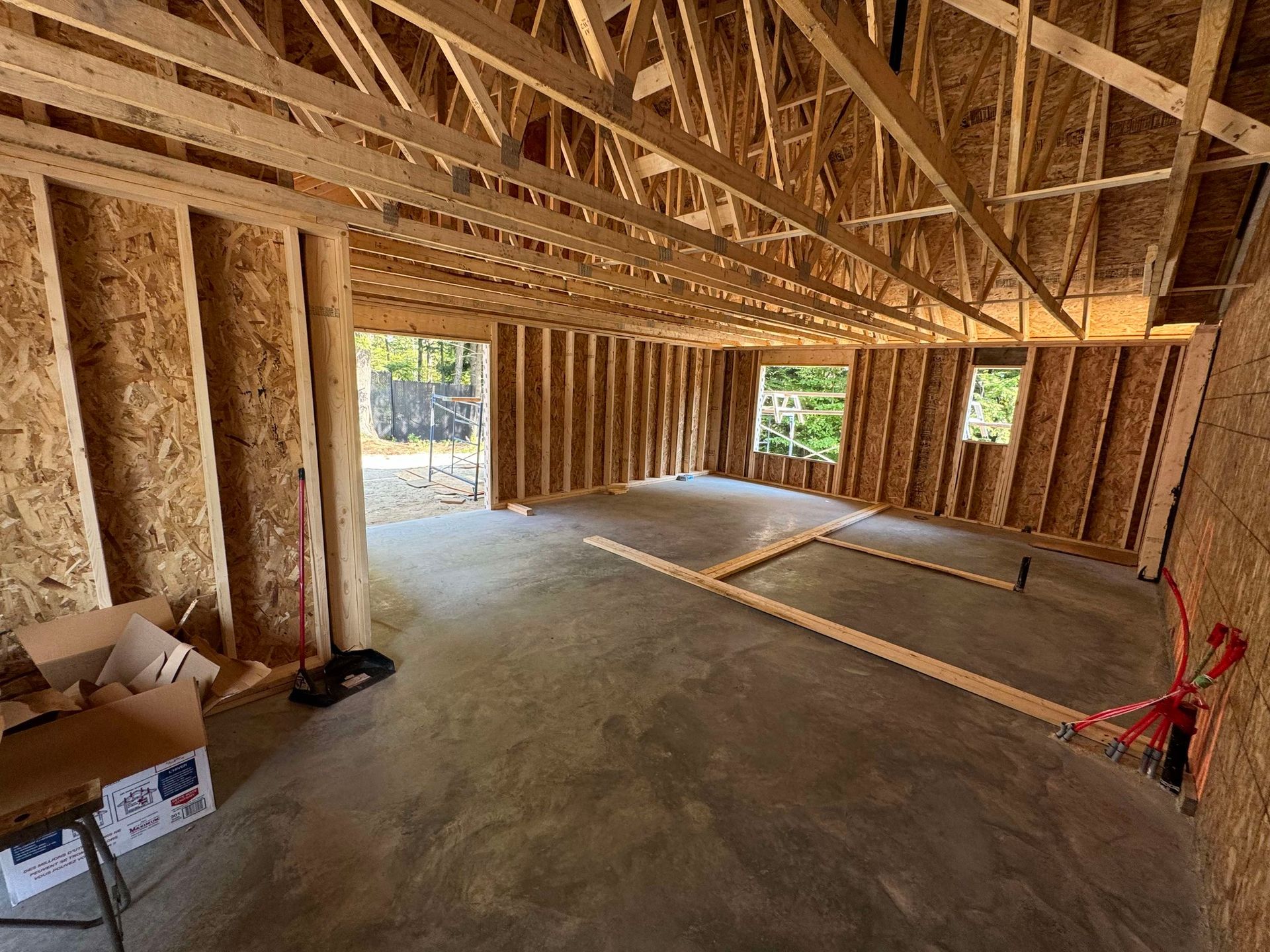 Une pièce en construction avec des poutres en bois et un sol en béton.