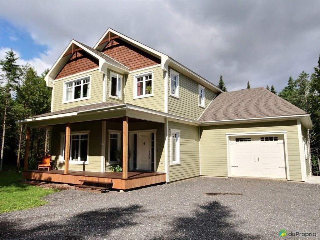 Une grande maison avec un porche et un garage