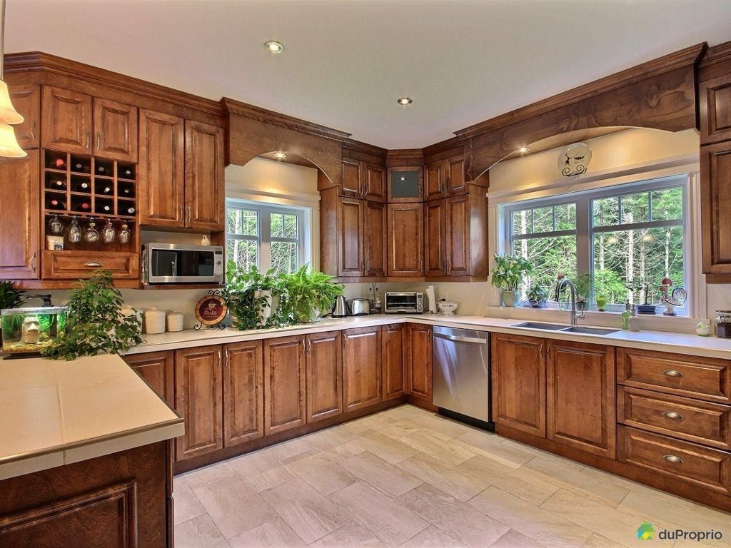 Une grande cuisine avec des armoires en bois et des appareils en acier inoxydable.