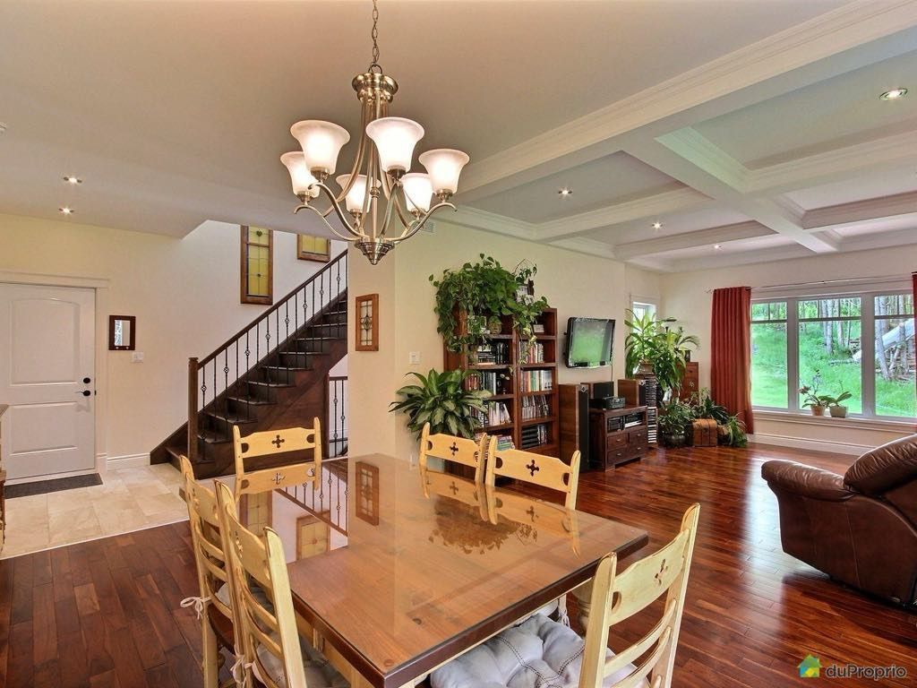 Une salle à manger avec une table et des chaises et un lustre.