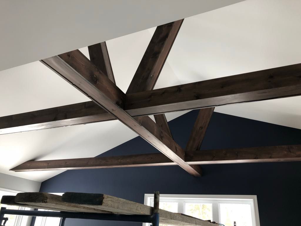 Une pièce avec un plafond voûté et des poutres en bois.