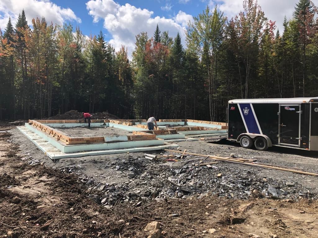 Une remorque est garée devant un bâtiment en construction.