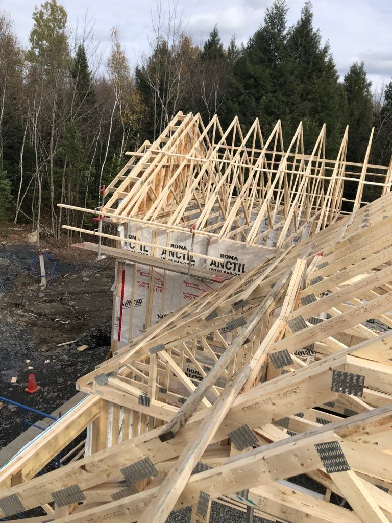 Le toit d'une maison est en train d'être construit avec des poutres en bois.