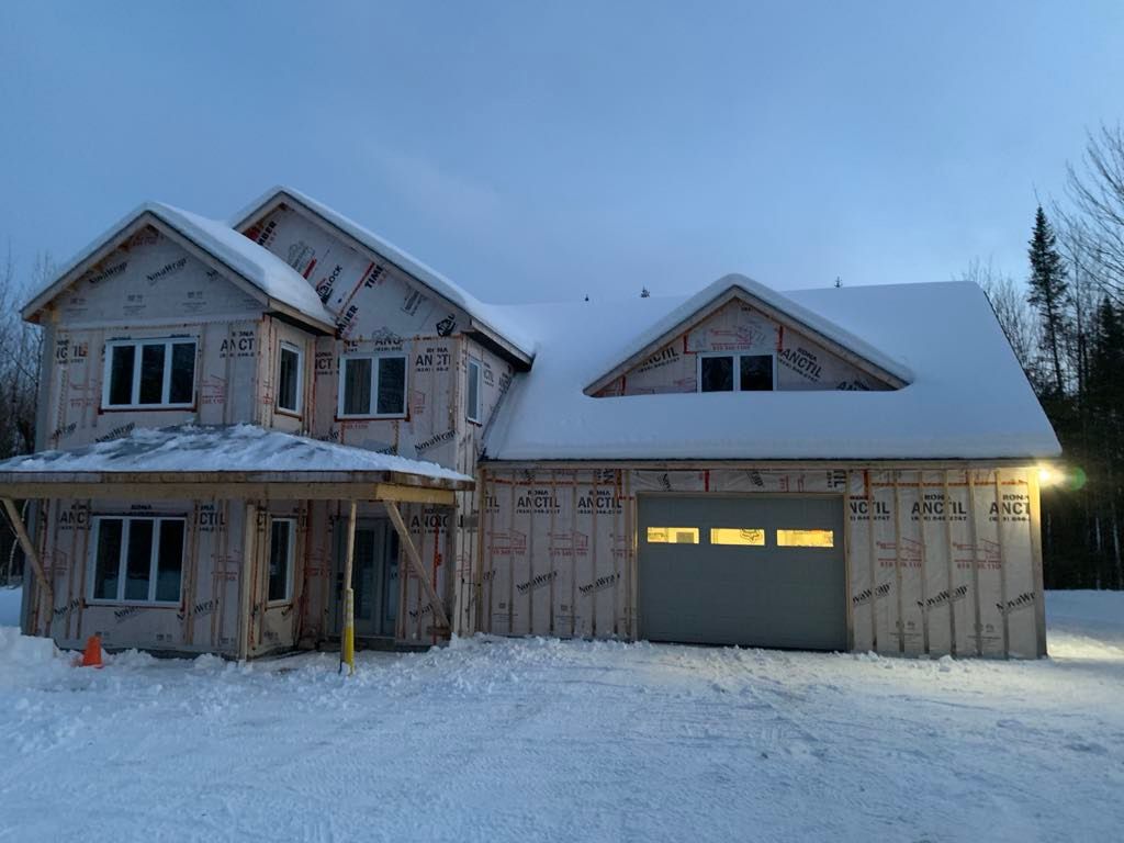 Une maison qui se construit dans la neige
