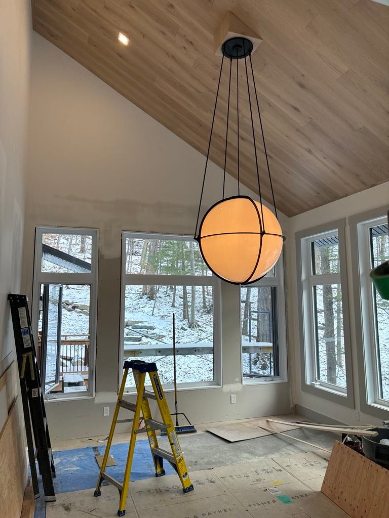 Un grand lustre est suspendu au plafond d'une pièce avec beaucoup de fenêtres.