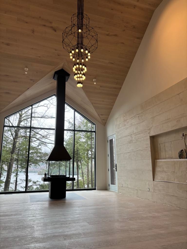 Il y a une cheminée au milieu de la pièce avec beaucoup de fenêtres.