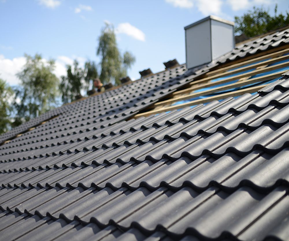 Dark metal roof under construction with exposed wood.